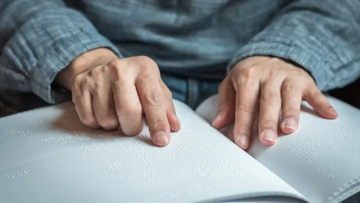 elderly man reading brail