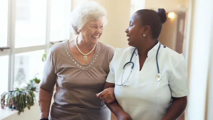 nurse and elderly woman smiling together